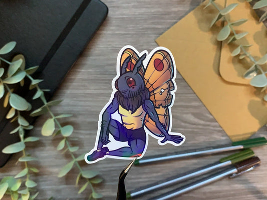 Water resistant vinyl sticker for the cryptid, Mothman. This cute mothman sticker has a holo laminate finish, and is the perfect addition to your water bottle, a sticker for your planner, and is a great way to show your appreciation and love of cryptids