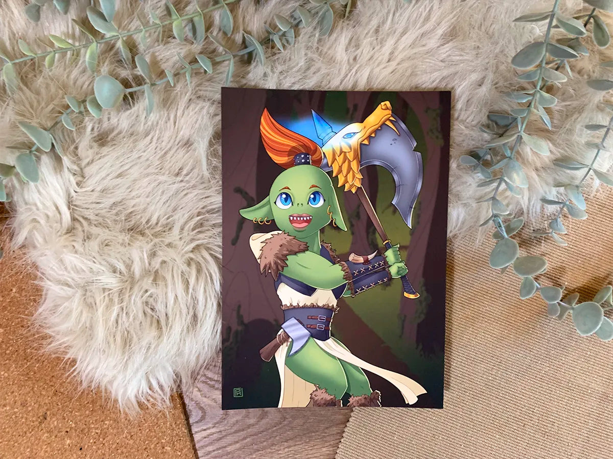 A vibrant illustration of a goblin-like warrior holding a large axe. The character has green skin, pointed ears, and blue eyes, and they are dressed in a fur and leather outfit. The character’s orange hair is tied up in a ponytail, and they are grinning with sharp teeth showing. The axe they hold has a golden wolf-shaped adornment at the top, with the blade shining in silver. The background is a woodland setting